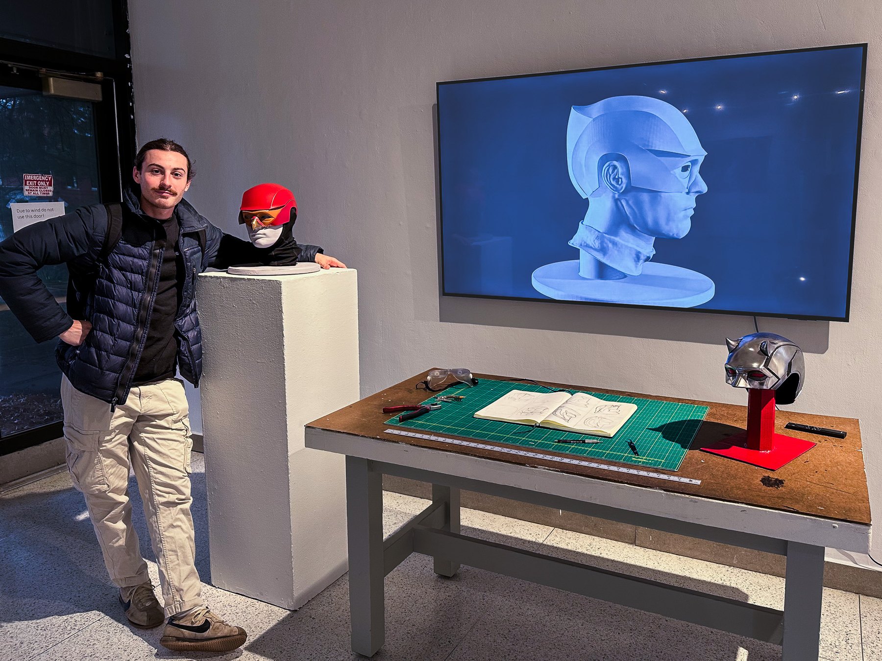 Zane Devlin holding the finished Eclipse helmet at the gallery show