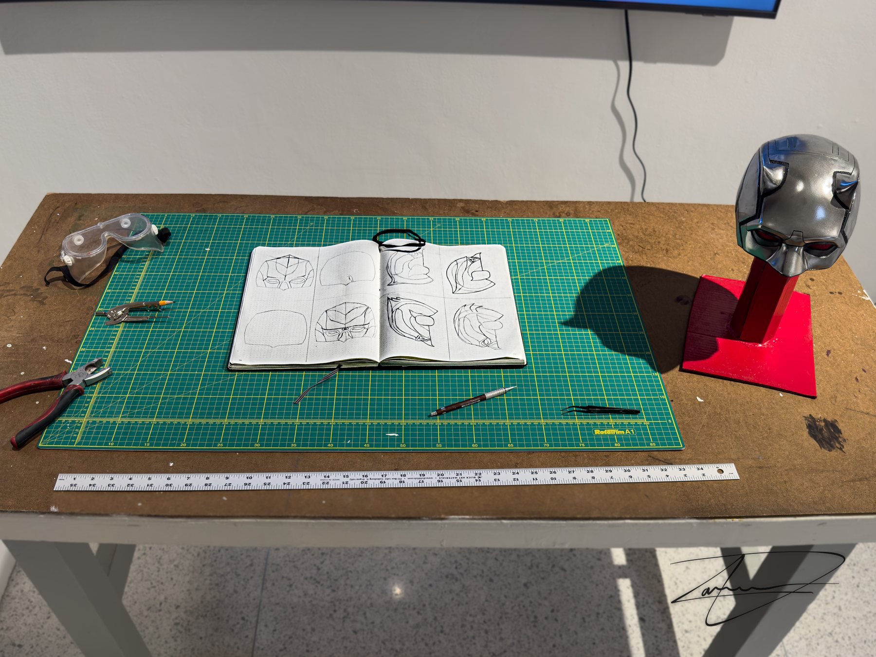 The workbench table, with the sketchbook, the cutting mat and the Daredevil replica.
