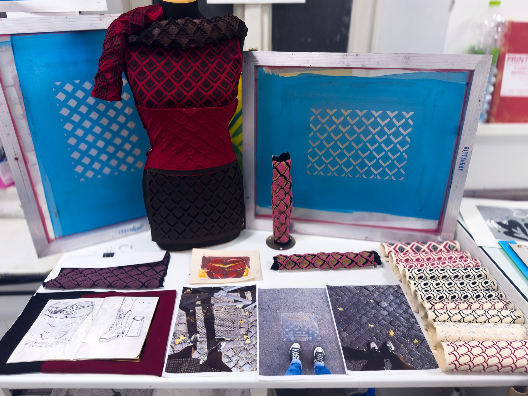 The work laid out at the end of the semester: the printed garment on a dress form, the screens behind it, sketchbook and printed cloth